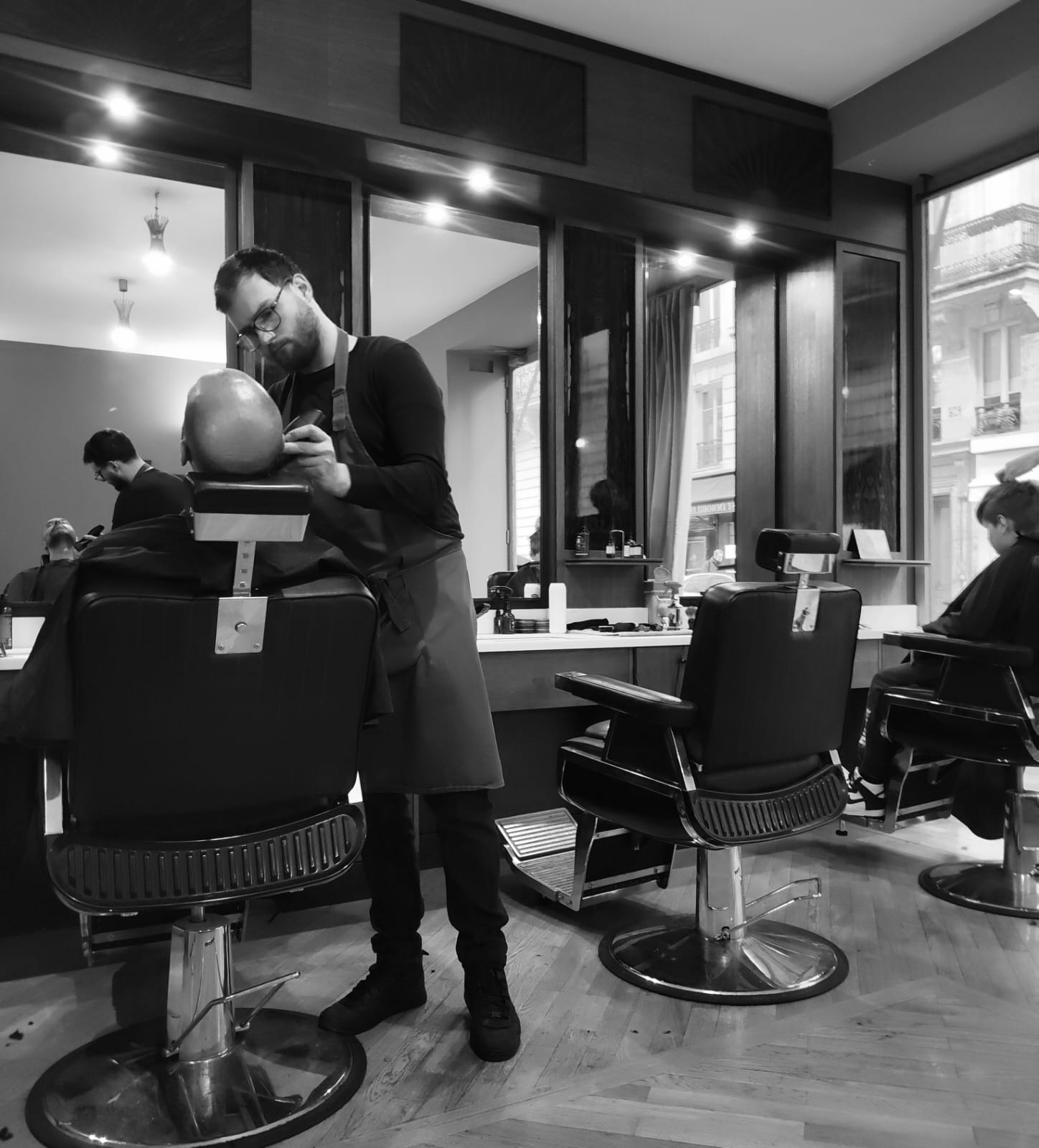 Barbier au travail — salon Longchamp Paris 16e, noir et blanc